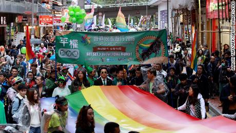 Participants of Hong Kong&#39;s annual pride parade walk through the streets with a large rainbow flag on November 26, 2016. 