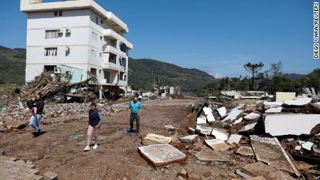 People walk in front of a damaged building in Mucum, Rio Grande do Sul, Brazil, September 6, 2023. 
