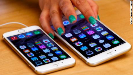 A woman touches an iPhone 6 Plus as it sits next to an iPhone 6 after they went on sale at the Apple Store in Sydney on September 19, 2014. 