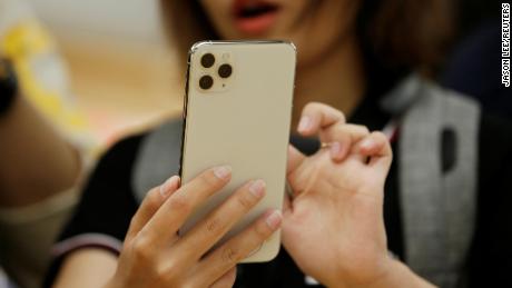 A woman holds an iPhone 11 Pro Max while giving a live broadcast after it went on sale at the Apple Store in Beijing, China, on September 20, 2019.