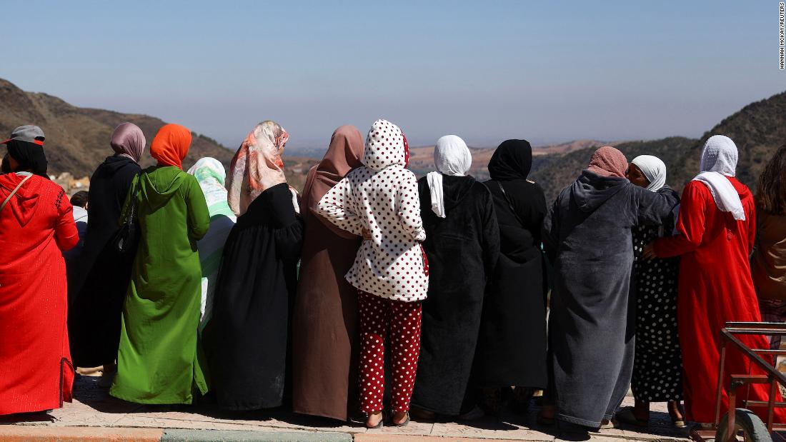 Women watch the funeral of two victims in Moulay Brahim on September 10.
