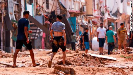 People inspect an area damaged by flash floods in Derna, in eastern Libya, on Monday.