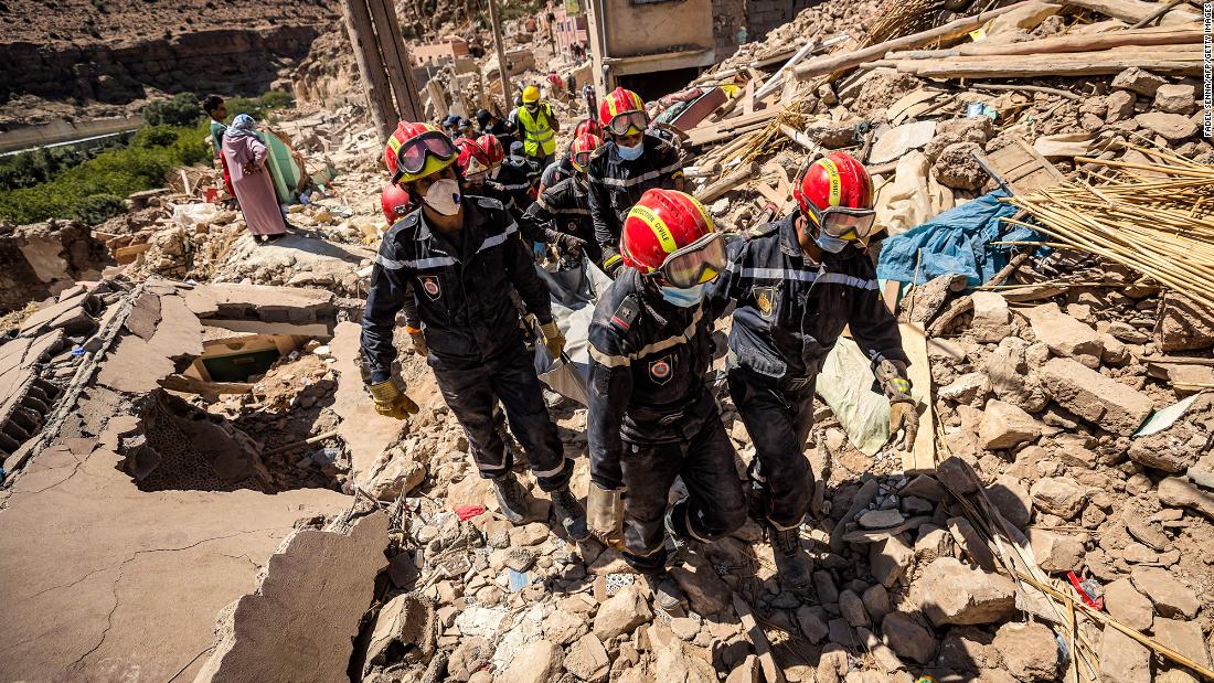 Rescue workers carry a body from a damaged house in Imi N&#39;Tala, a village near Amizmiz, on September 13.