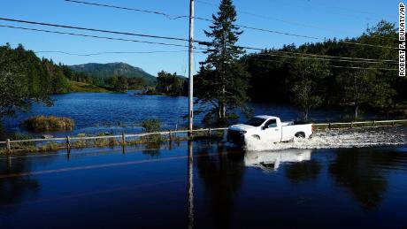A motorist travels through flood waters near Northeast Harbor, Maine.