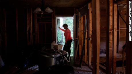 A homeowner walks through her flood-damaged house in Lost Creek, Kentucky, on September 29, 2022.