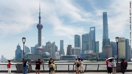 Tourists look out onto the Lujiazui financial district in Shanghai, which is part of the city&#39;s pilot free trade zone and home to hundreds of banks and financial service firms.