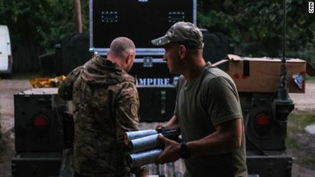 Ukrainian soldiers load drones and ammunition into the back of a US-donated Humvee before a night-time assault.
