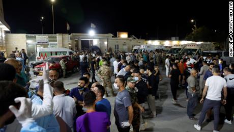 People gather outside a hospital in Iraq&#39;s Nineveh province on Wednesday, where survivors of the blaze are being treated.