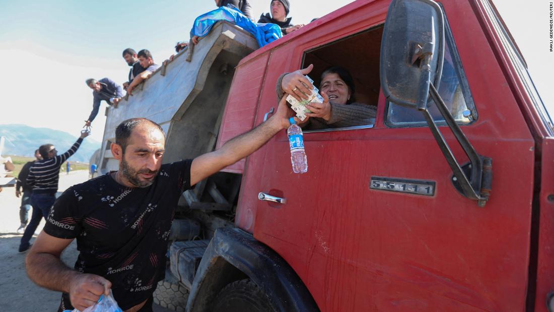 David Harapetyan, an ethnic Armenian and taxi driver who came to Kornidzor from Russia to provide assistance, hands food and water to people from Nagorno-Karabakh on September 27.