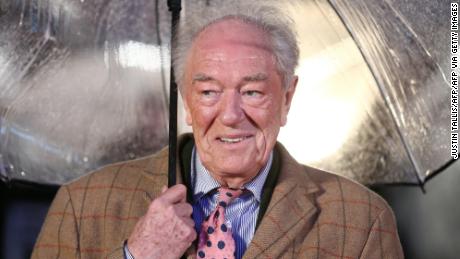 British actor Michael Gambon shelters from the rain as he arrives for the world premiere of the film Dad&#39;s Army in London on January 26, 2016. (Photo by JUSTIN TALLIS / AFP) (Photo by JUSTIN TALLIS/AFP via Getty Images)