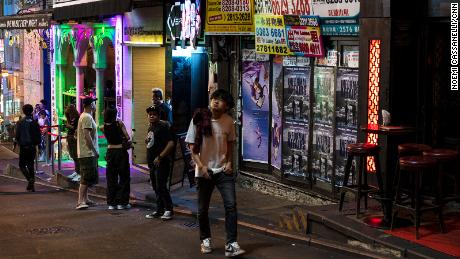 A man walks past a closed bar along a near-empty street in the Soho area of Hong Kong.