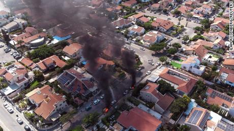 An aerial view shows vehicles on fire as rockets are launched from the Gaza Strip, in Ashkelon.