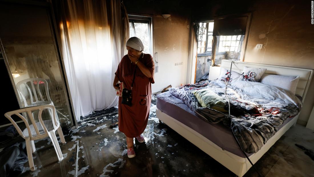 A woman stands in a room damaged by rockets in Ashkelon on October 7.