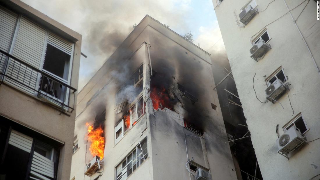 A building in Tel Aviv is ablaze Saturday, October 7, following rocket attacks from Gaza.