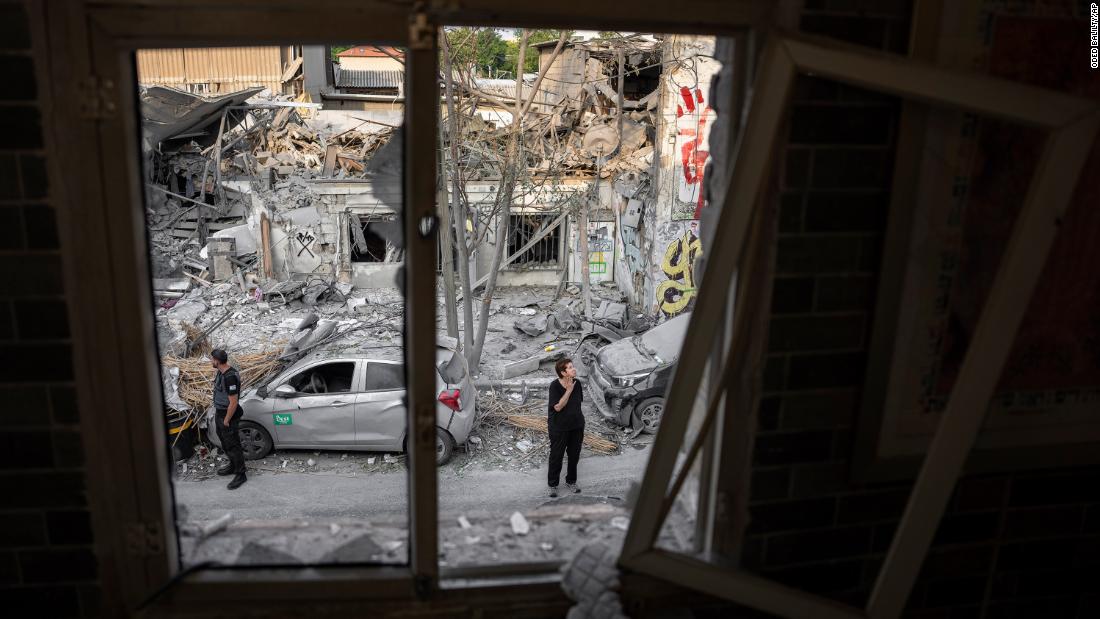 Israelis inspect the rubble of a building in Tel Aviv on October 8, a day after it was hit by a rocket fired from Gaza.