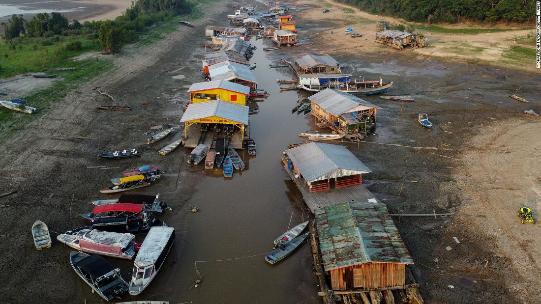 A floating village is stranded on a dry lakebed as extreme drought grips the Amazon