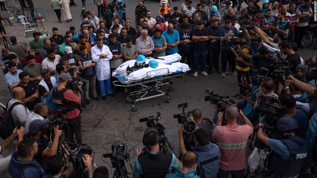 People gather around the bodies of two Palestinian reporters, Mohammed Soboh and Said al-Tawil, who were killed by an Israeli airstrike in Gaza City on October 10.