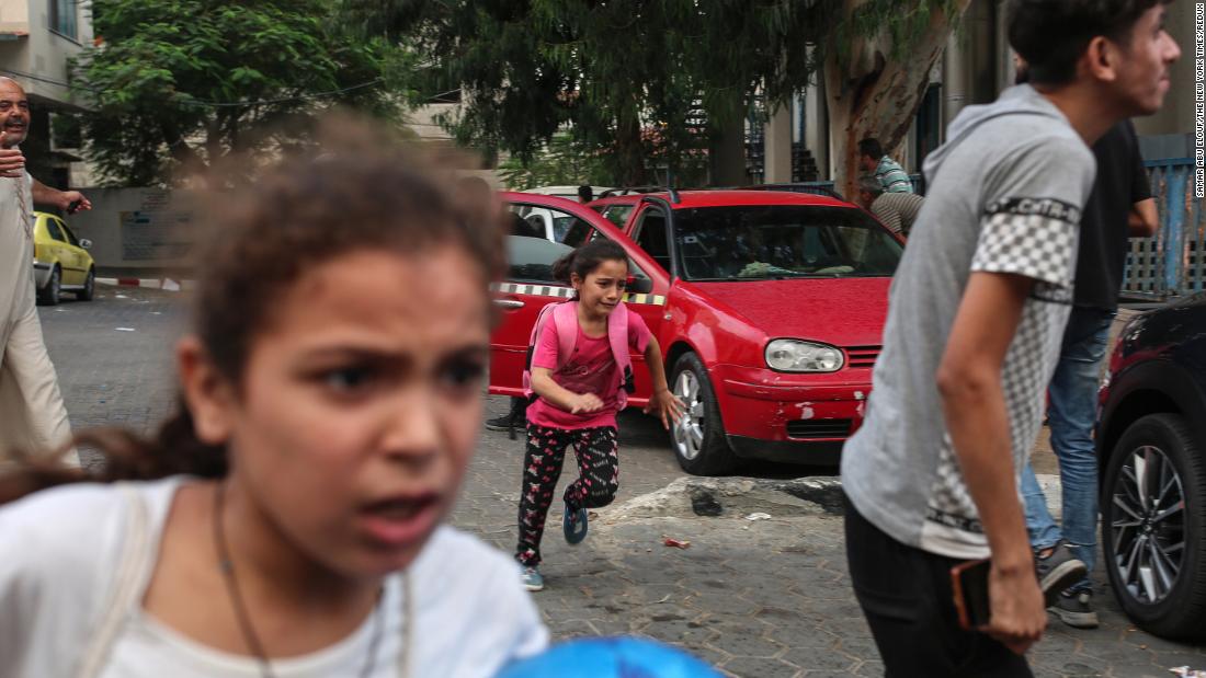 Children run for cover as bombs fall near the Al-Shifa Hospital in Gaza City on October 9.