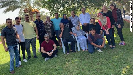 Aref Abou-Amro, in the center back with his arms over sisters, and the rest of the family, including many nephews and nieces, who are trapped in Gaza.