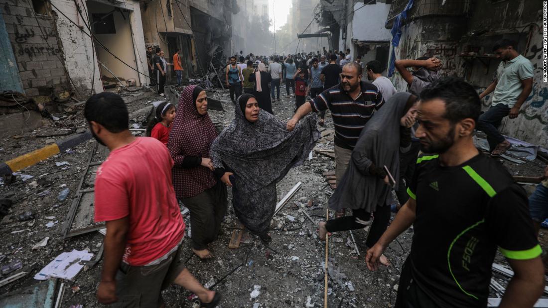 People react at the site of an Israeli airstrike in Al-Shati refugee camp in Gaza City on Saturday, October 14.