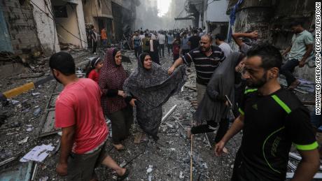People at the site of an Israeli rocket attack in Al- Shati refugee camp in the west of Gaza City on October 14. 