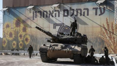 Israeli soldiers gather on and around a tank near Israel&#39;s border with the Gaza Strip, in southern Israel on October 15.