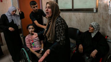 A Palestinian woman reacts to people wounded by Israeli airstrikes, at al-Aqsa hospital, in central Gaza, on October 15. Relief workers warn the bombardment is destroying the health care system.