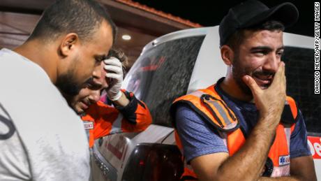 Palestinian paramedics cry outside al-Shifa hopsital, in Gaza City, on Monday. Humanitarian groups say the Israeli blockade and airstrikes on the Palestinian enclave are in violation of international law. 