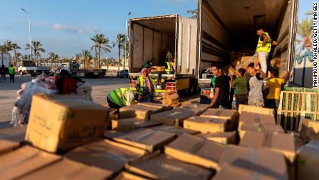 Volunteers load food and supplies onto aid trucks on October 16, in North Sinai, in Egypt. Israeli strikes have blocked efforts to bring humanitarian aid into Gaza through the Rafah crossing.