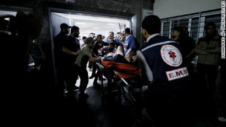 An injured person is assisted after Al-Ahli Baptist Hospital was bombed on Tuesday. 