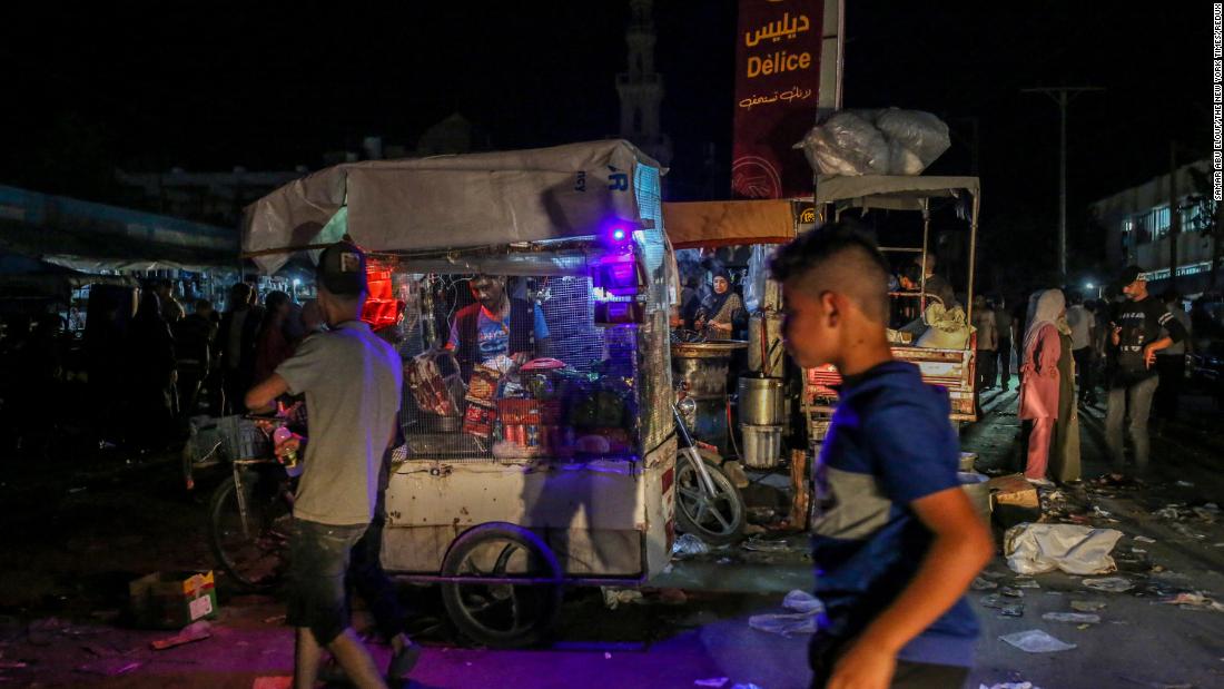 Street vendors work on a darkened street without power in Khan Younis, Gaza, on October 16.