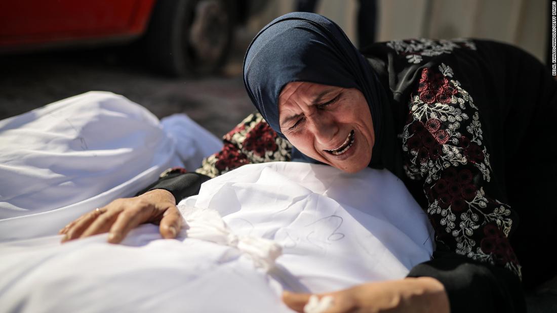 A woman mourns over a dead man at the Al-Aqsa Martyrs Hospital in Gaza City on October 18.