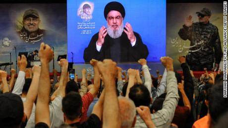 Hezbollah supporters raise their fists to salute party leader Hassan Nasrallah in May 2023.