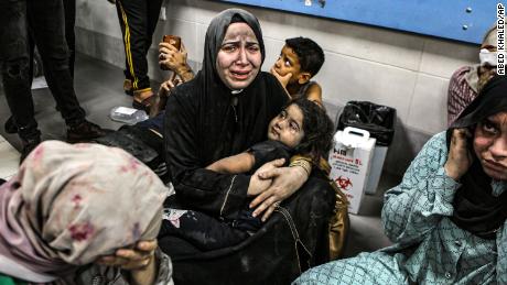 Wounded women and children sit on the floor at the Al-Shifa Hospital after being transported from the Al-Ahli Baptist Hospital following a blast there on Tuesday, October 17.