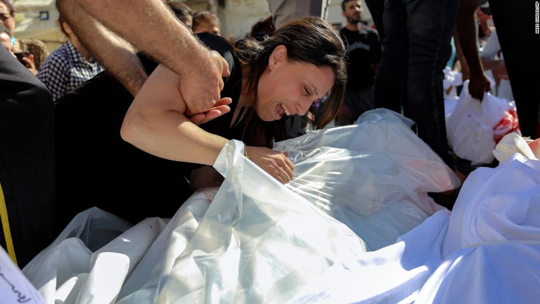 A Palestinian woman mourns over the bodies of her relatives who were killed an Israeli airstrike that hit a Greek Orthodox church in Gaza City on October 20.