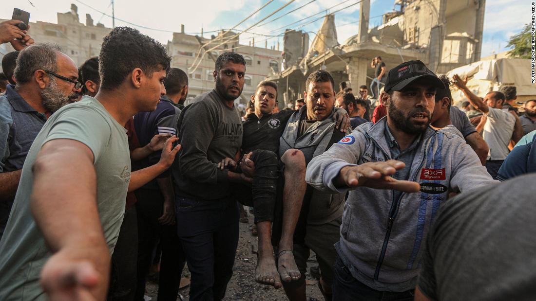 Injured civilians are recovered from the rubble of a destroyed house following Israeli air strikes near a UNRWA school housing displaced people in Khan Younis, Gaza, on Saturday, October 21. 