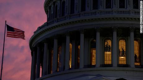People walk inside the upper floors of the rotunda of the US Capitol building at sunset on January 4, 2023.