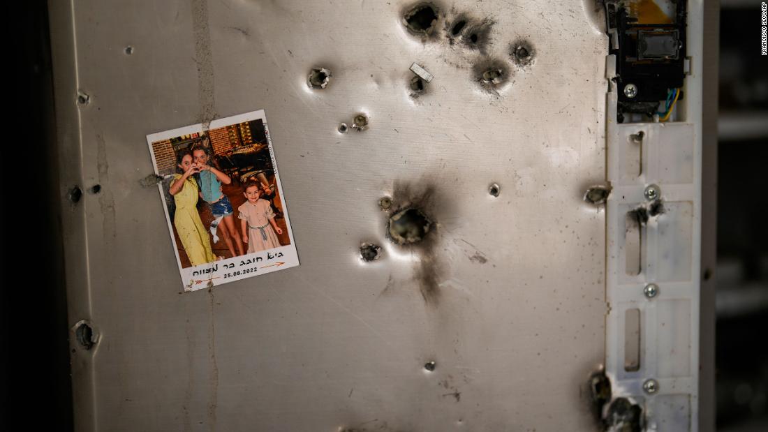 A photo hangs on a refrigerator dotted with bullet holes in a home in Kibbutz Kissufim, Israel, on October 21.