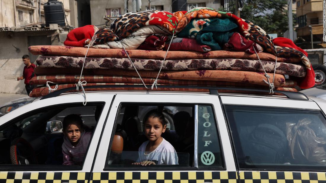 Palestinian children sit in a vehicle loaded with household items in Khan Younis refugee camp, in Khan Younis, southern Gaza, on October 28.