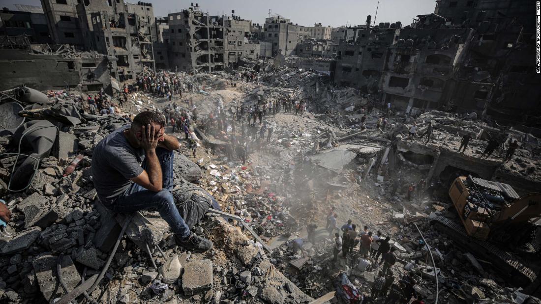 A man sits on debris as Palestinians conduct a search and rescue operation after the second bombardment to the Jabalya refugee camp in Gaza City, on Wednesday, November 1.