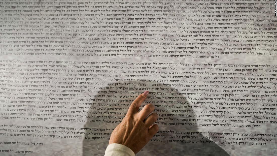 A woman looks for names on a memorial wall in Jerusalem&#39;s Old City on November 6 that lists the 1,400 people killed in the October 7 attack by Hamas militants on Israel.