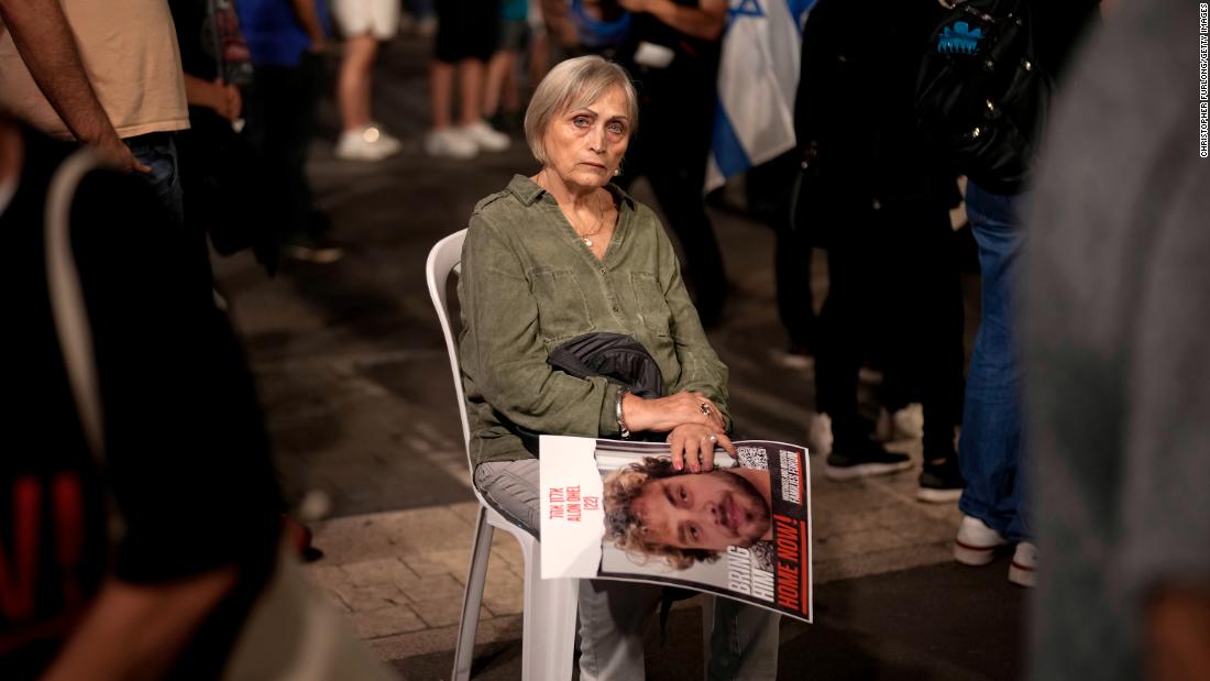 On day 35 of hostages being detained by Hamas, a woman holds the image of a hostage while sitting amongst thousands of people and families of kidnapped people taking part in a protest to demand that Israeli Prime Minister Benjamin Netanyahu secures the release of Israeli hostages, on Saturday, November 11, in Tel Aviv, Israel. 
