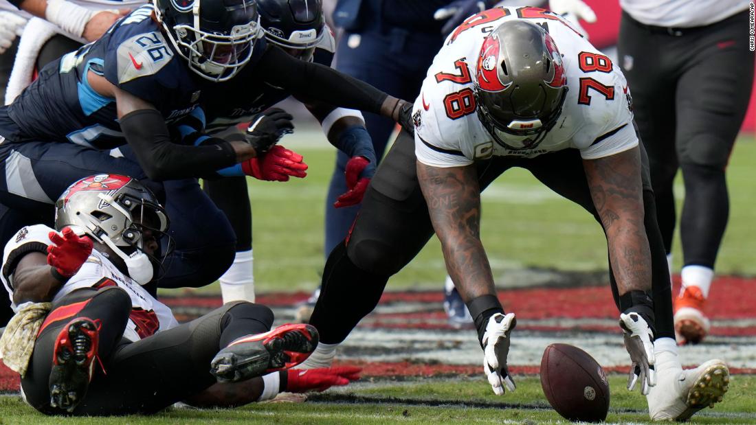 Tampa Bay Buccaneers offensive tackle Tristan Wirfs recovers a fumble on November 12. The Buccaneers beat the Tennessee Titans 20-6. 