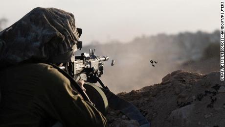 An Israeli soldier fires his weapon in Gaza on November 13, 2023.