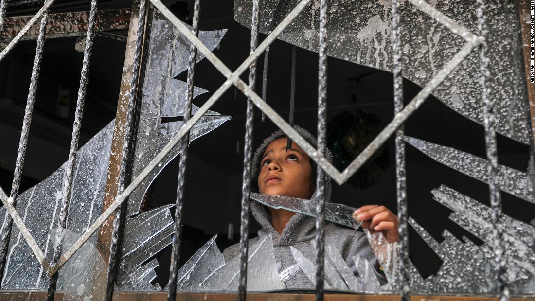 A Palestinian child looks through a broken window of a destroyed building, in Rafah, Gaza, on Wednesday, November 15.
