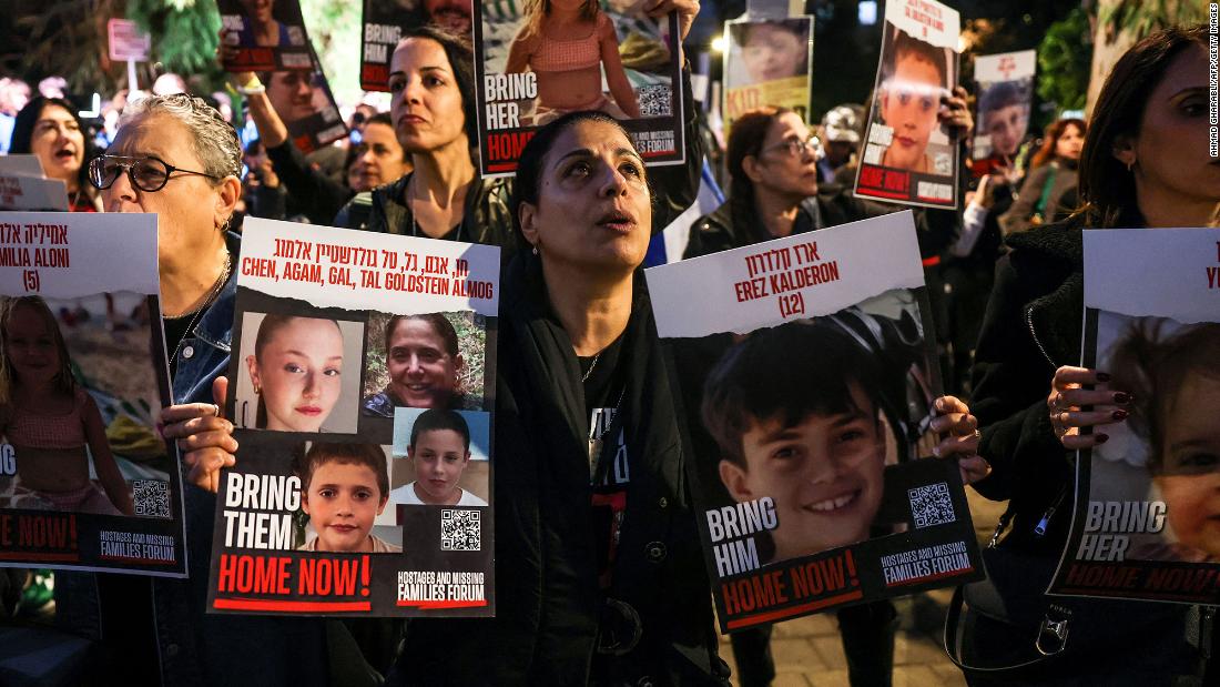 People hold portraits of children held hostage by Hamas as protesters rally outside the Unicef offices in Tel Aviv, Israel, on November 20.