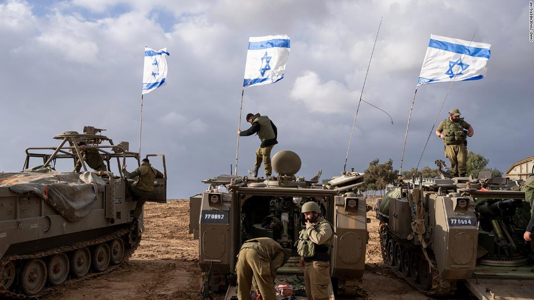 Israeli soldiers work on armored military vehicles along Israel&#39;s southern border with the Gaza Strip, on November 20.