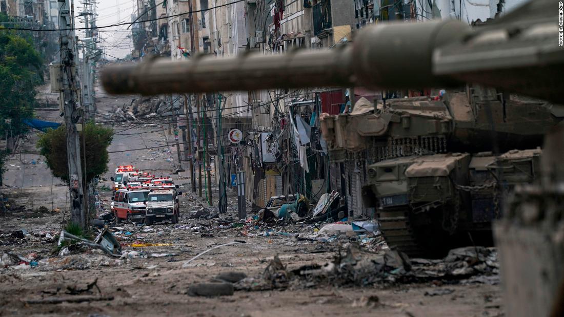 Ambulances are seen on a road near an Israeli forces tank in Gaza on November 22.