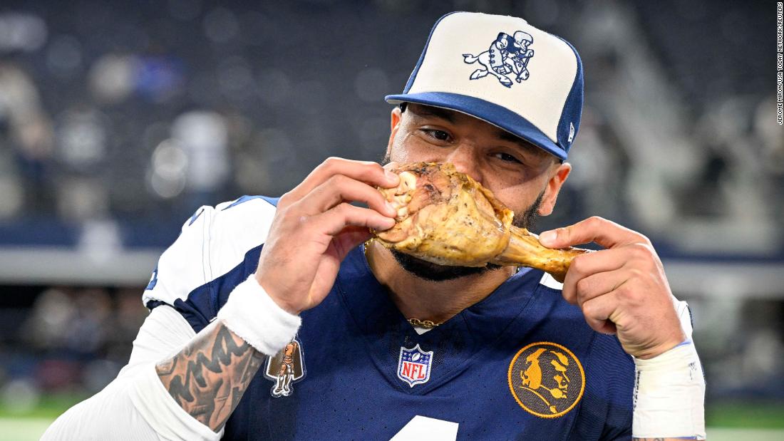 Dallas Cowboys quarterback Dak Prescott eats a turkey leg after the Cowboys&#39; 45-10 Thanksgiving Day victory over the Washington Commanders on November 23.
