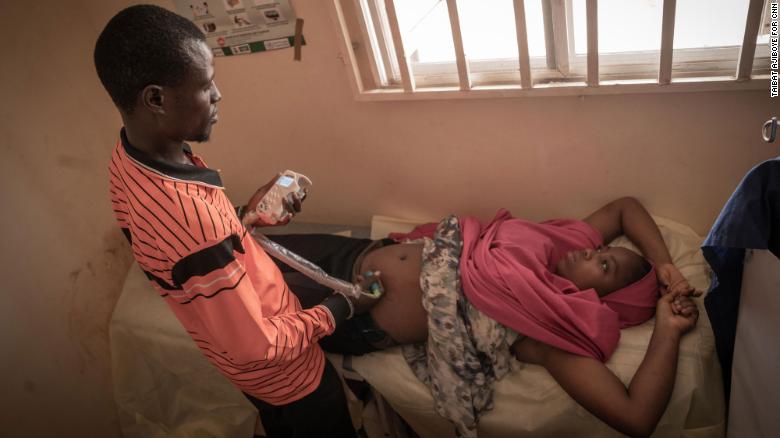 The camp nurse, Isa Umar examines a pregnant woman during antenatal session